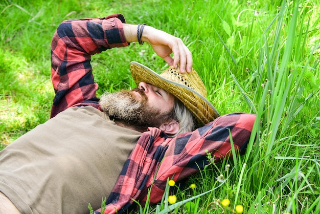 La nature est ma maison. Repos à la campagne. L'homme barbu d'agriculteur se repose après le travail de jour. Agriculteur se détendre sur l'herbe verte. Notion d'écologie. Vacances d'été. Unis avec la patrie. Environnement écologique. Repos d'été.