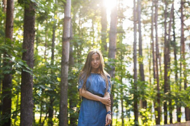 Nature, gens et concept d'été - Portrait de jeune femme appréciant la forêt verte.