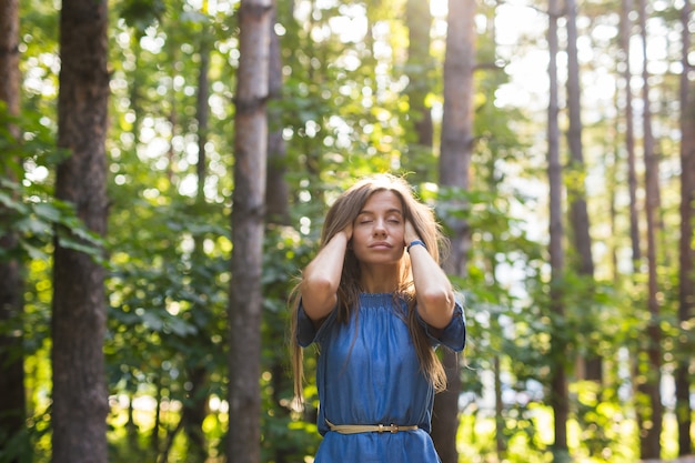 Nature, gens et concept d'été - Portrait de jeune femme appréciant la forêt verte.