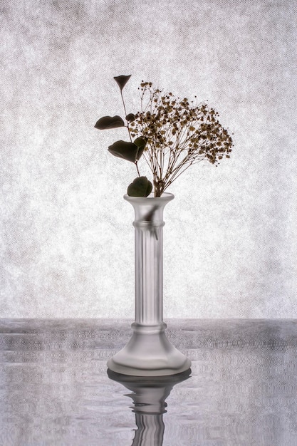 Nature morte au bouquet dans un vase en verre sur fond gris