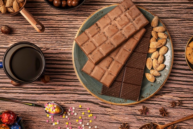 Nature morte au chocolat en barres avec café et thé chocolats noisettes et amandes salées torréfiées