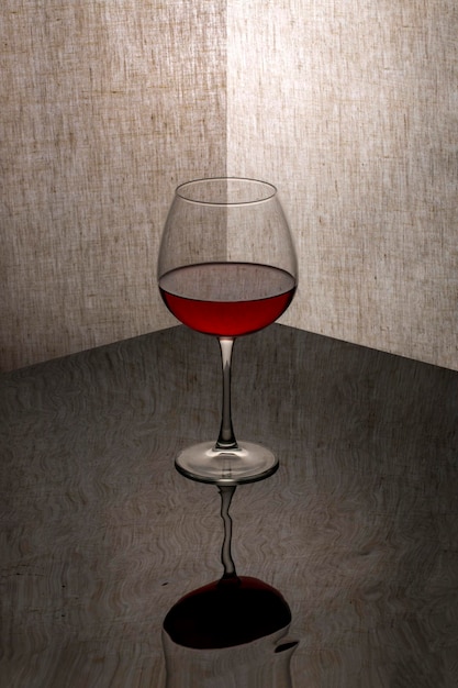 Nature morte au gobelet en verre avec du vin dans le coin