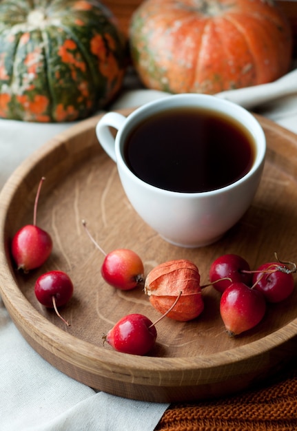 Nature morte d'automne avec café, citrouille, physalis et petites pommes rouges