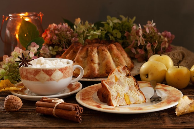 Nature morte d'automne confortable avec tarte aux pommes aux biscuits chauds et boisson chaude à la guimauve