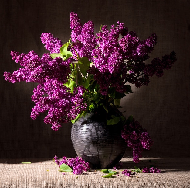 Nature morte aux branches fleuries de lilas dans un vase