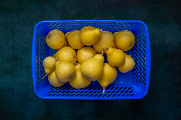 Nature morte aux citrouilles décoratives jaunes en forme de poire dans une boîte bleue