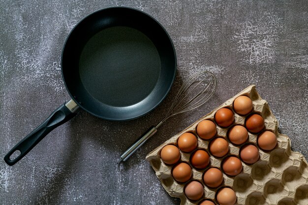 Nature morte aux œufs et à la poêle sur la vue de dessus de table en boisAnimal