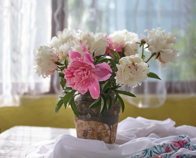 Nature morte aux pivoines blanches et roses dans un vieux vase en céramique