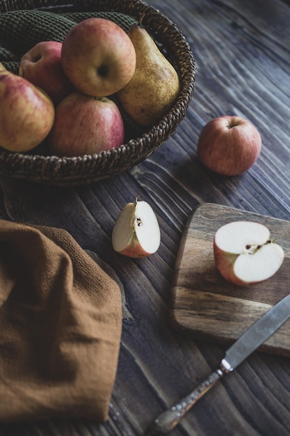 Nature morte aux pommes dans un panier en osier sur une table en bois