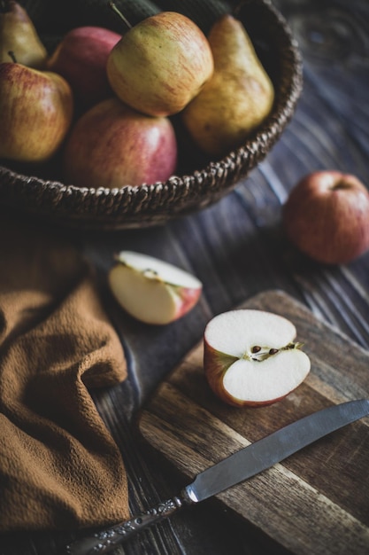 Nature morte aux pommes dans un panier en osier sur une table en bois