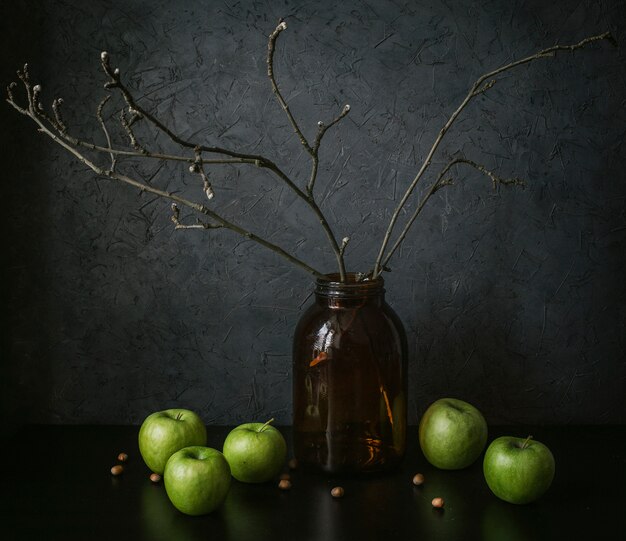 nature morte aux pommes et un vase sur fond sombre