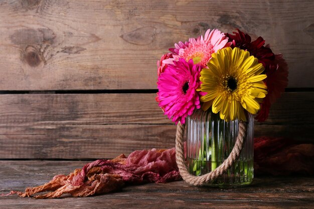 Nature morte avec de belles fleurs de gerbera lumineuses sur fond de bois