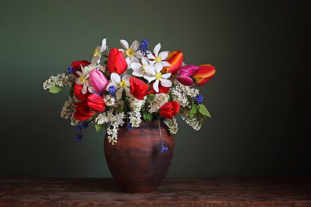 Nature morte avec un bouquet de printemps dans un pot en argile.