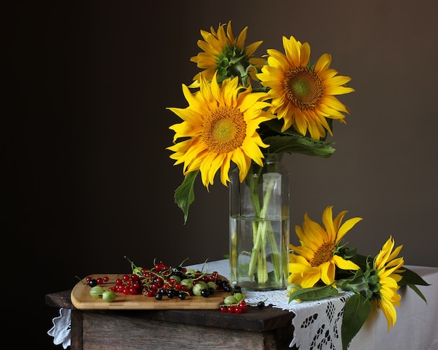 Nature morte avec un bouquet de tournesols et de baies de jardin