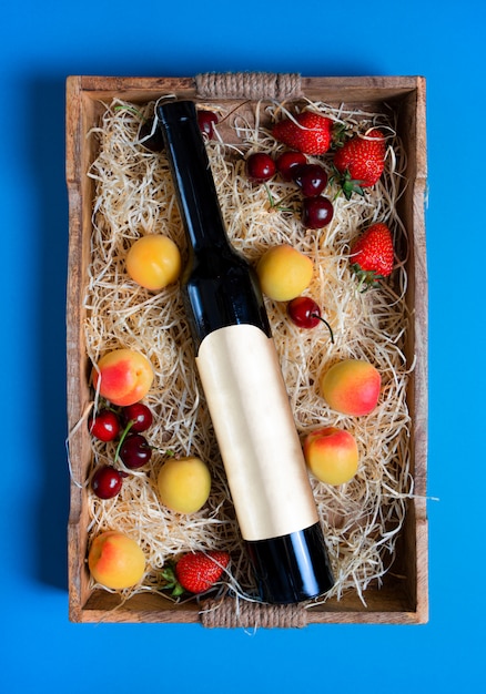 Nature morte avec bouteille et fruits sur le plateau en bois rustique