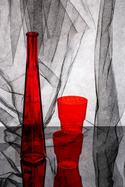 Nature morte avec une bouteille rouge et un verre rouge