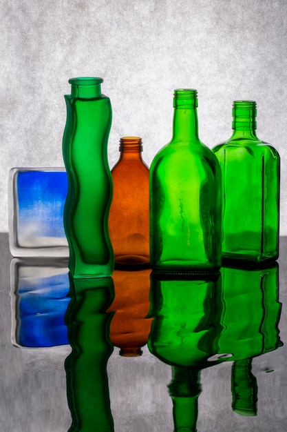 Photo la nature morte avec des bouteilles de verre colorées