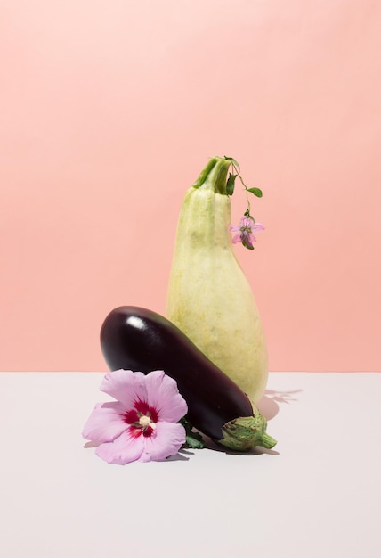 Photo nature morte avec courgettes et fleurs d'aubergines concept créatif créatif sur fond dégradé