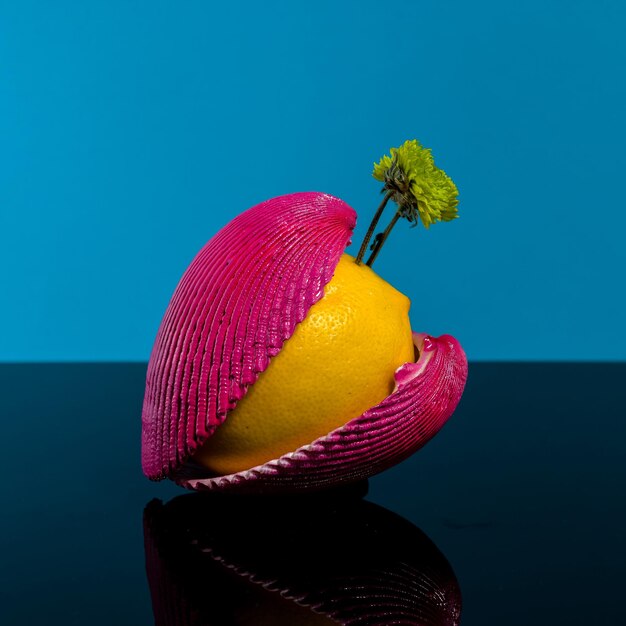 Nature morte créative avec du citron et des coquillages sur un fond bleu