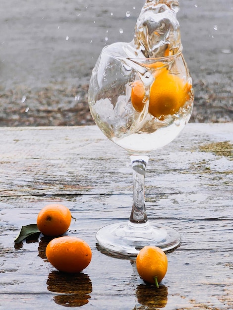 nature morte élégante sur un fond en bois d'une boisson dans un verre éclaboussures de verre de cocktail alcoolisé