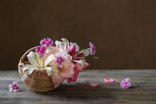 Nature morte avec des fleurs d'été dans le panier sur dark