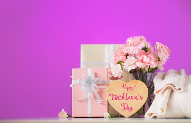 Nature morte avec des fleurs d'oeillet doux et cadeau sur table, concept de fête des mères