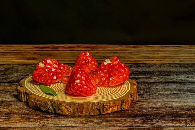 Nature morte de grenades sur une table en bois et un fond noir