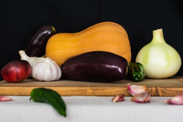 Nature morte de légumes aux aubergines courge musquée ail poivrons et tomates