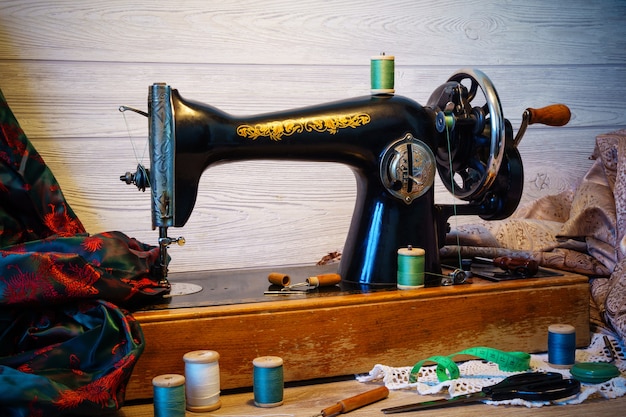 Nature morte avec machine à coudre ancienne et divers accessoires de couture