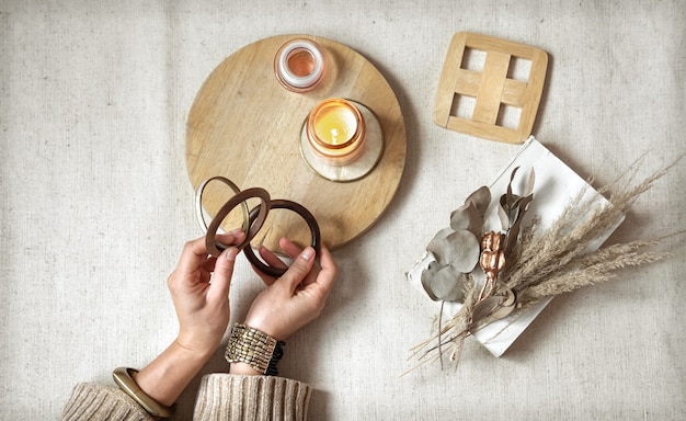 Nature morte avec des mains féminines en bracelets sur la surface du décor en bois et vue de dessus de fleurs séchées.