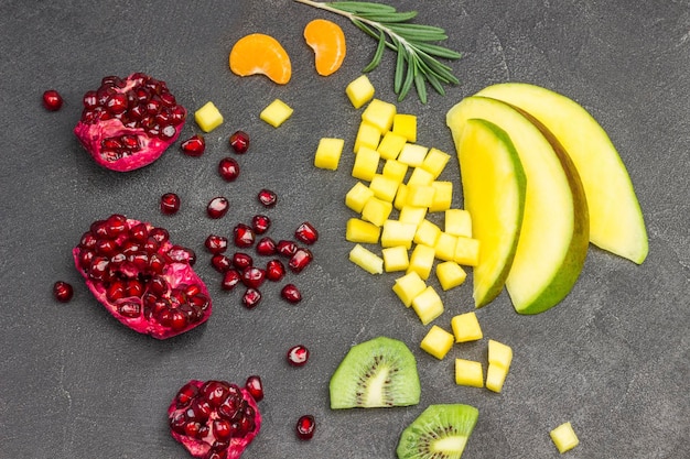 La nature morte de la mangue, de la grenade et du kiwi sur le noir