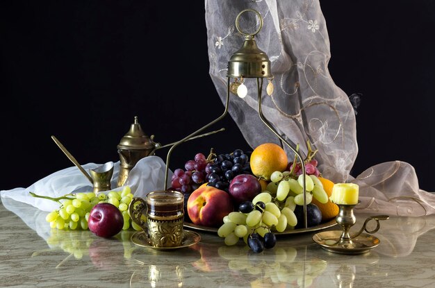 Nature morte orientale avec fruits d'été variés et café dans une tasse en verre sur un gros plan de table