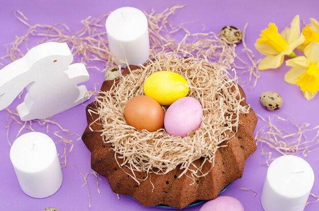 Nature morte de Pâques, gâteau de Pâques, œufs de poulet et de caille, sur fond violet.