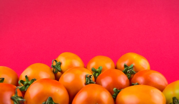 Photo nature morte, photographie culinaire d'art. tomates fraîches avec un beau fond rose magenta.