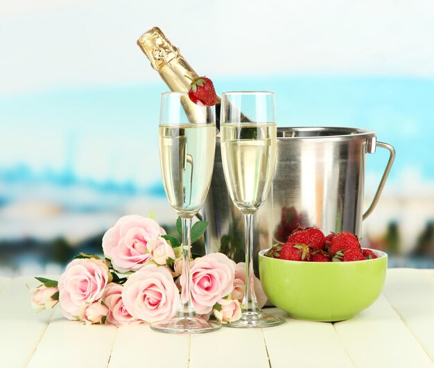 Photo nature morte romantique avec champagne fraise et roses roses sur fond clair