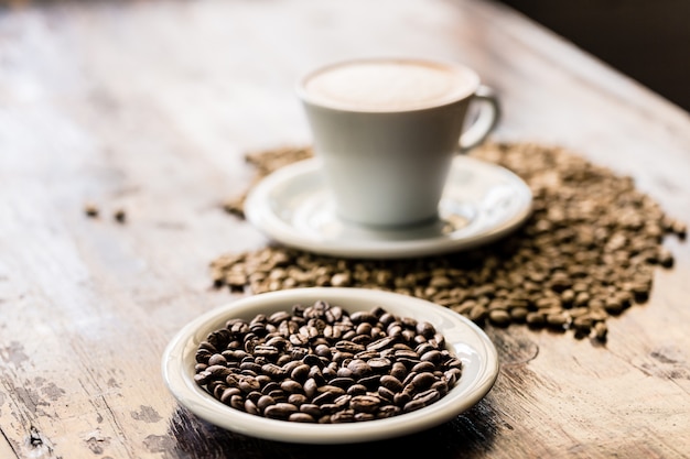 Nature morte de tasse de cappuccino et de grains de café