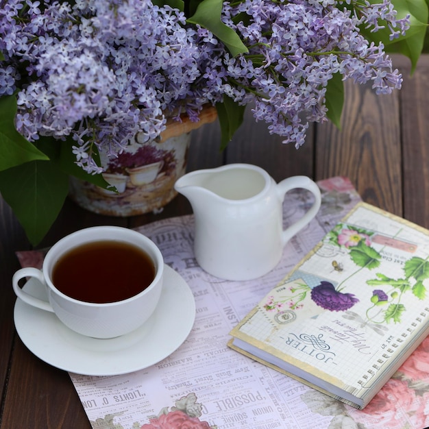 nature morte avec une tasse de thé du matin et des fleurs de lilas