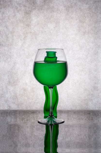 Nature morte avec un vase vert et un verre de liquide