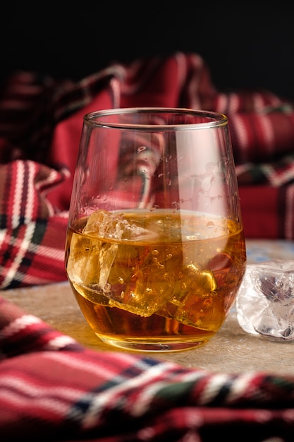 Photo nature morte avec un verre de bourbon. un verre de whisky avec de la glace. concept de rate d'automne