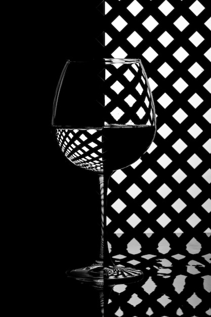 Nature morte avec un verre de liquide sur un fond de grille