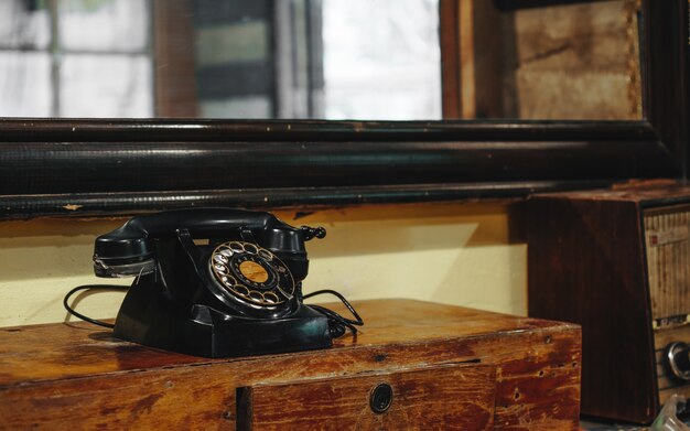 Nature morte de vieux téléphone rétro vintage noir sur la table en bois de style asie