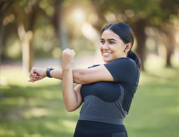 Nature de remise en forme et femme heureuse qui s'étire dans un parc extérieur pour la santé, le bien-être et l'entraînement Athlète sportive en bonne santé et fille du Mexique faisant un exercice d'échauffement avant une séance d'entraînement dans un jardin verdoyant