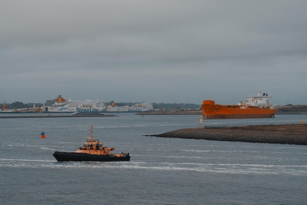 Photo navette-citerne moderne alimentée au gnl nouvellement construite dans le port avec deux ferries à passagers