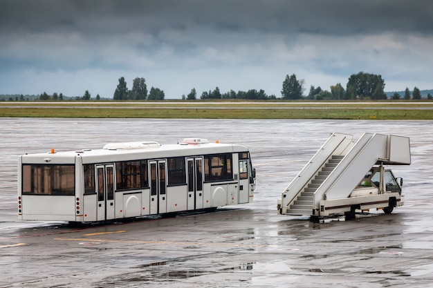 Navette et escaliers d'embarquement des passagers sur le tablier de l'aéroport un jour de pluie