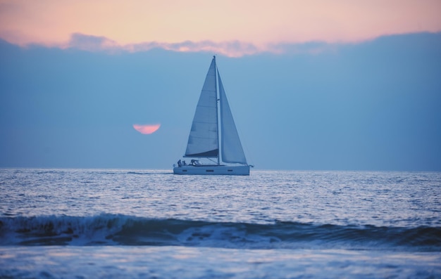 Naviguer au lever du soleil avec un voilier