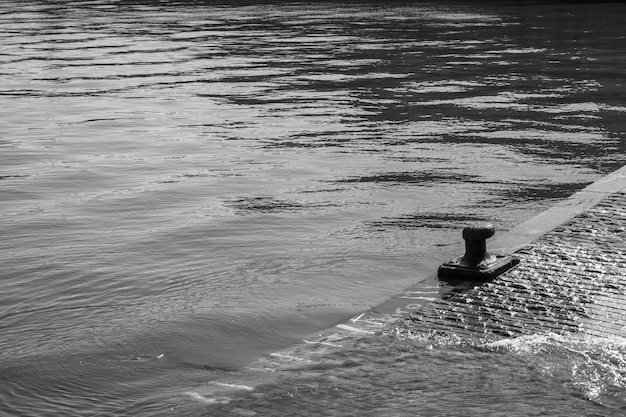 navire amarré au port avec une mer calme en noir et blanc