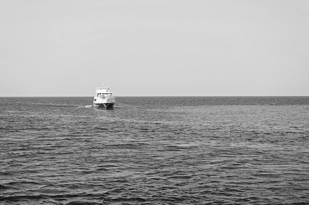 Navire ancré dans la mer bleue à l'horizon du ciel ensoleillé Voyager en bateau de mer Vacances d'été et loisirs Transport par eau et navire