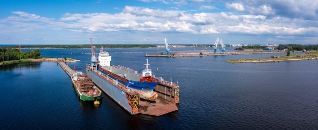 Navire en cale sèche flottante en réparation par sablage au chantier naval