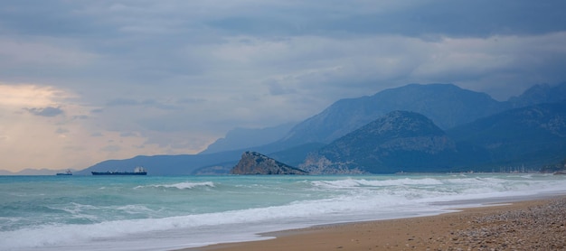 Navire de cargaison en bleu calme Méditerranée à Antalya Voyageant le long de la mer Méditerranée vue de la côte rocheuse d'Antalya Au loin, des navires de cargaison sont visibles