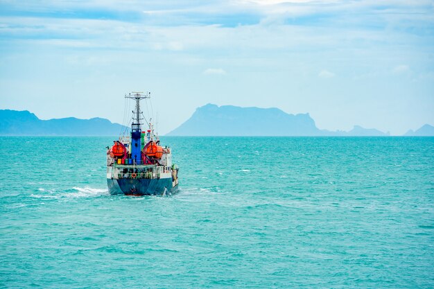 Navire cargo en mer et colline par journée ensoleillée